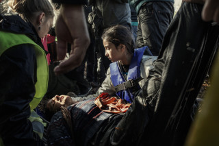 Lesvos. Greece. Oct. 25, 2015. An Afghan girl looks after her mother, who has fainted, after landing on the beach of Eftalou on the north of the Greek island of Lesvos.
