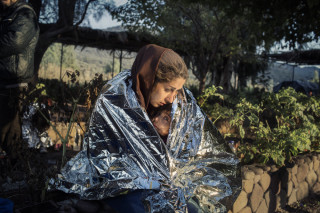 Lesvos, Greece Oct. 18, 2015. A mother and child  wrapped in an emergency blanket after disembarking on the beach of Kayia, on the north of the Greek island of Lesvos.