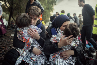 Lesvos. Greece. Oct. 21, 2015.
 A Syrian couple embrace their two young children just after landing on the beach of Kayia, on the north of the Greek island of Lesvos. The journey was turbulent because of bad seas.