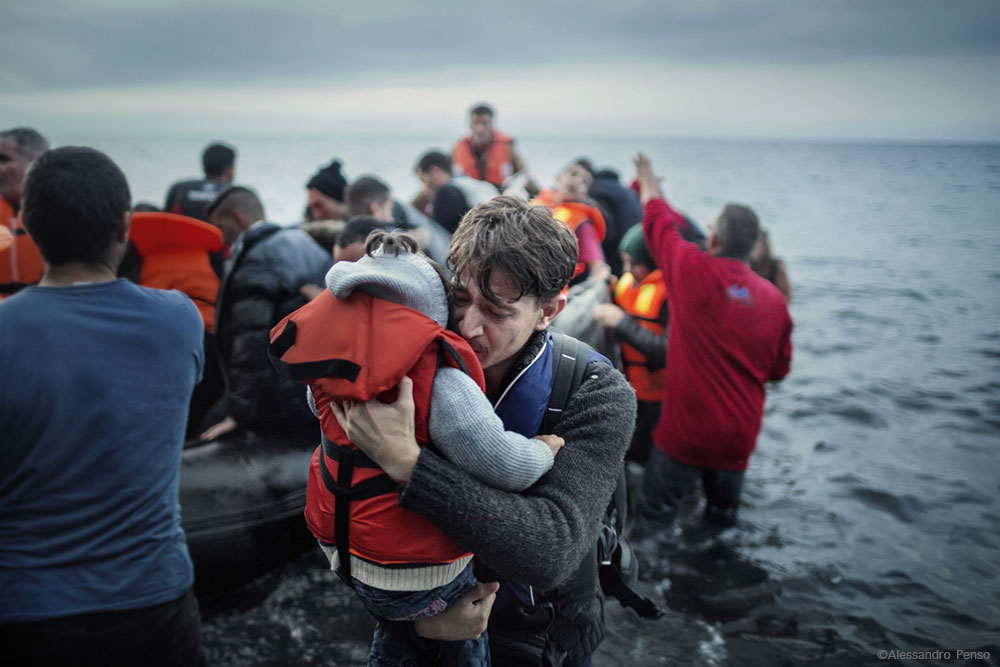 Lesvos. Greece. Oct. 21, 2015. A  father hugs his young daughter as they land on the Greek island of Lesbos,  after crossing the Aegean sea from the Turkish coast